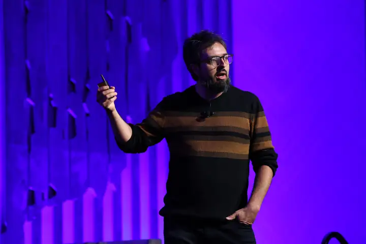 Carl Franzen speaking on stage during a live technology conference presentation